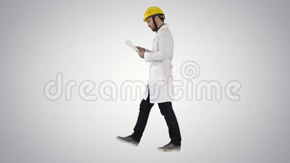 工程师经理带着安全帽走路拿着纸检查梯度背景视频的预览图
