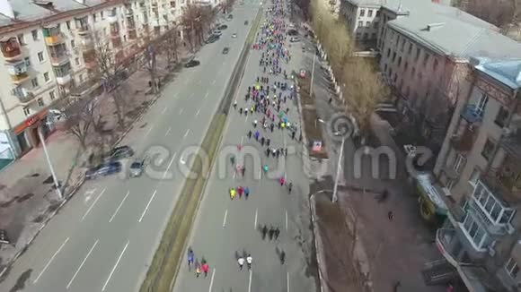 城市马拉松运动员在空路上跑步的空中射击视频的预览图