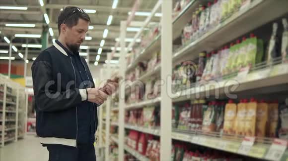 超市的男客正在比较两瓶番茄酱视频的预览图