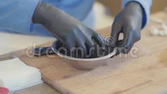 厨师的双手戴着黑色橡胶手套在餐厅厨房里用铝碗准备特别的食物视频的预览图