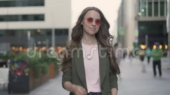 一个年轻漂亮的女人在秋天的街道上竖起大拇指视频的预览图