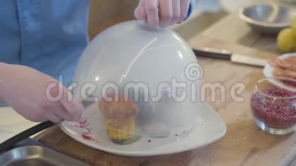 手把干冰从管子放到一个有玻璃罩的大盘子里分子厨房视频的预览图
