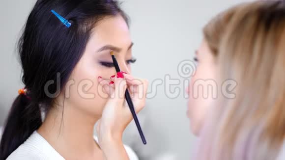 侧视专业视觉师在美容工作室用刷子涂眉妆视频的预览图