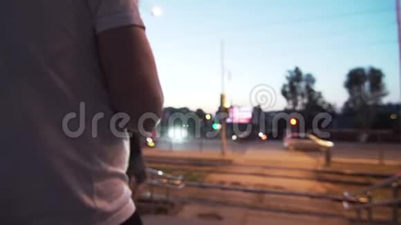 一名身穿白色t恤站在路边的不明身份青年男子的后视镜视频的预览图
