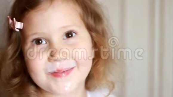 小女孩喝一瓶牛奶饮料kefir乳制品孩子微笑着露出白色的胡子视频的预览图