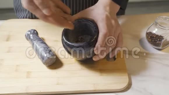 厨师用石臼和杵自信地研磨一系列草药和香料视频的预览图
