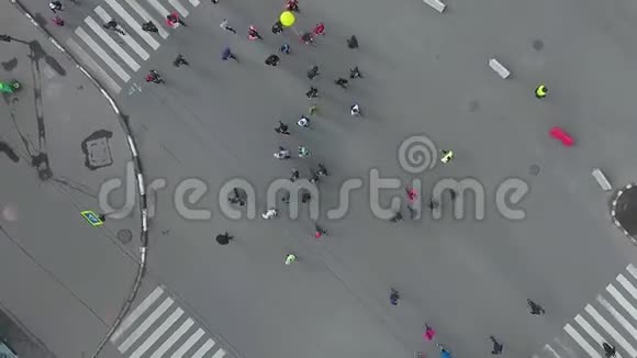 从高空拍摄的与城市马拉松赛跑的人的道路交叉口视频的预览图