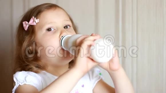 小女孩喝一瓶牛奶饮料kefir乳制品孩子微笑着露出白色的胡子视频的预览图