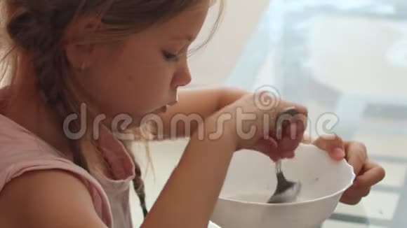 小金发女孩吃巧克力玉米片麦片碗早餐概念视频的预览图