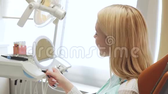 牙科诊所一名女性病人照镜子后景照片视频的预览图