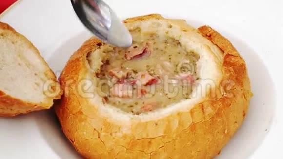 食物概念勺子招募汤将波兰传统汤称为zur或白色罗宋汤倒入面包碗视频的预览图