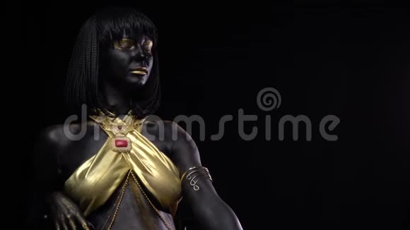 黑色和金色模特的身体艺术和化妆是坐黑色背景4k视频的预览图