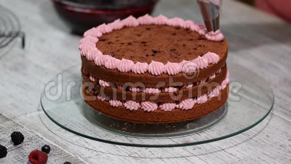 准备用浆果做巧克力蛋糕女手装饰蛋糕视频的预览图