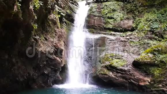 俄罗斯索契美丽的新鲜的瀑布在高大的岩石之间有绿色植物视频的预览图