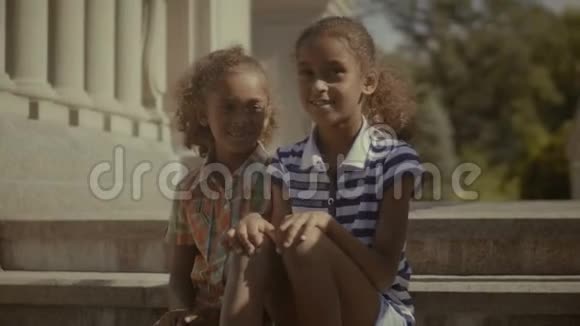 两个可爱的小女孩在楼梯上放松视频的预览图