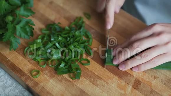 闭上厨师的手在木板上切葱概念蔬菜视频的预览图