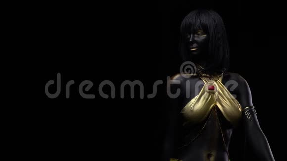 一位身穿黑色和金色身体艺术的女士坐着摆姿势4k视频的预览图