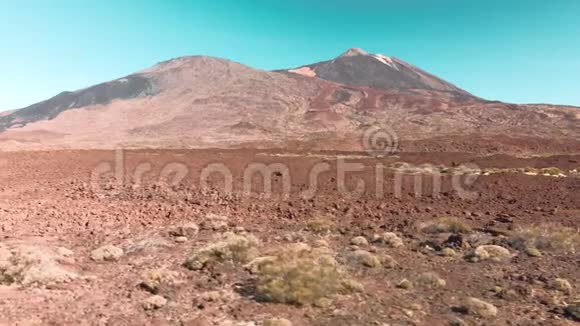 空中无人机射击沙漠火山火星景观呈红色石头和一座山和一座火山对抗蓝色视频的预览图
