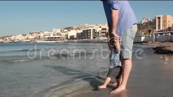 父子俩在沙滩上玩耍散步视频的预览图