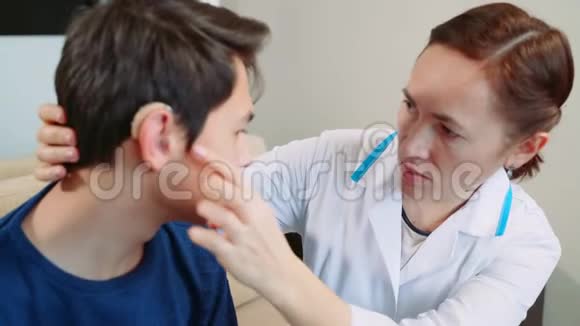 在医生办公室里的男孩少年戴上助听器视频的预览图