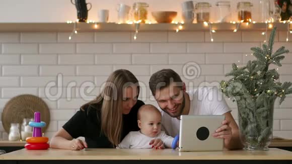 家庭父母和人的概念幸福的父母向婴儿展示平板电脑视频的预览图