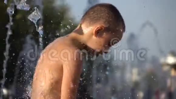 站在喷水池旁的秃头男孩视频的预览图