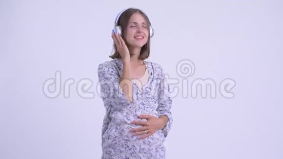 快乐的年轻孕妇边听音乐边思考视频的预览图