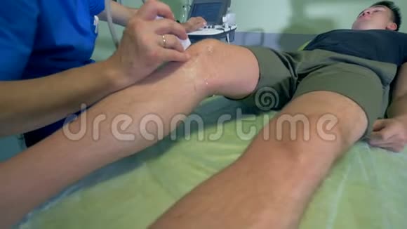 医生用超声波设备检查病人的膝盖和监视器4公里视频的预览图