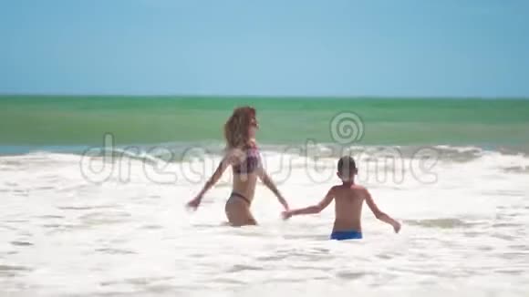 母子二人跳入大海上浪荡重新加入玩得开心视频的预览图