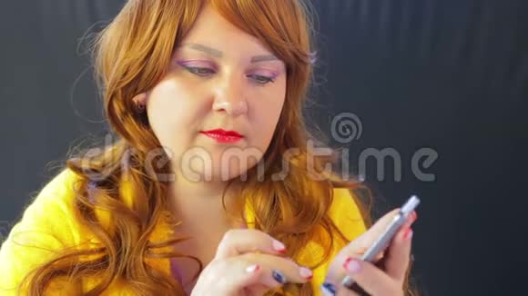 那个坐在桌旁的咖啡馆里的女孩在智能手机上翻阅着新闻视频的预览图