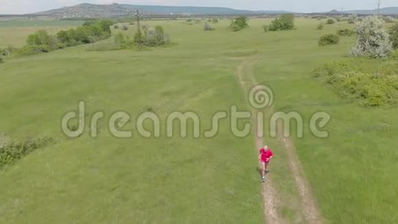 在草地路上奔跑的资深跑步者空中镜头视频的预览图
