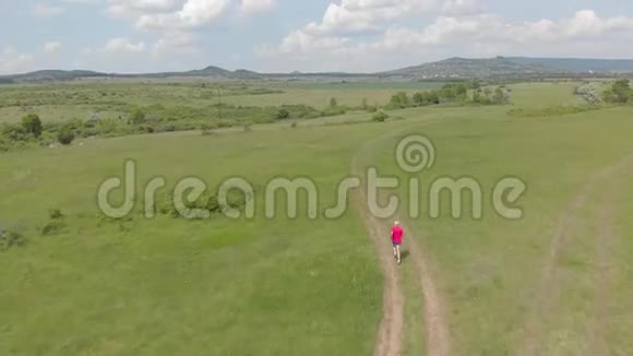 在草地路上奔跑的资深跑步者空中镜头视频的预览图
