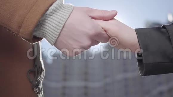 男人和女人的双手紧贴在城市景观前面男人牵着女友妻子的手我们的门日落视频的预览图