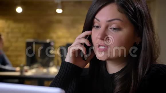 一位成年白种人深色头发的女商人坐在笔记本电脑前打电话视频的预览图