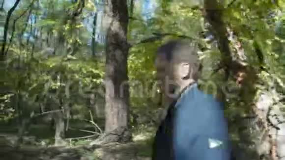 中镜头人走在秋天的森林里视频的预览图