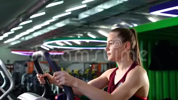 年轻女子在健身房进行有氧运动时使用阶梯踏步器视频的预览图
