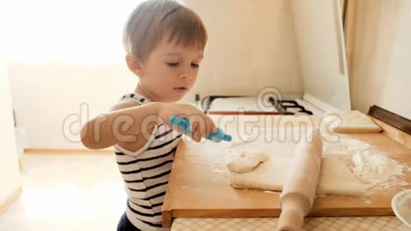 4k录像有趣的小男孩在厨房里学习做馅饼视频的预览图