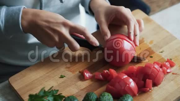 在木板上用刀切番茄把女人的手收起来概念蔬菜视频的预览图