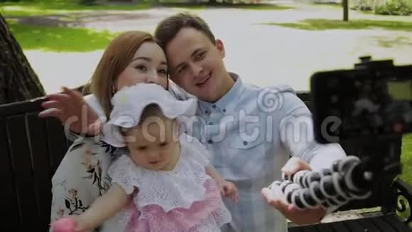 有孩子的幸福家庭在公园的长凳上自拍视频的预览图