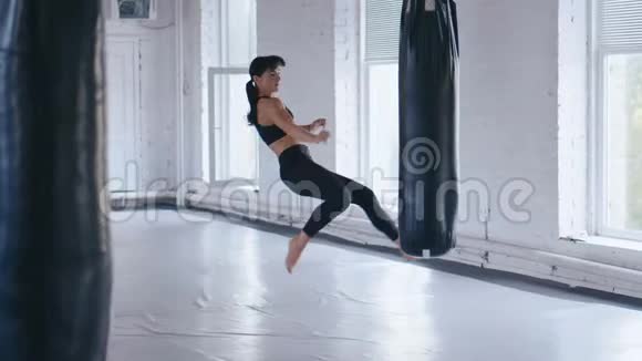 跆拳道职业运动员女子在健身房踢拳袋体育跆拳道女子在健身房训练视频的预览图