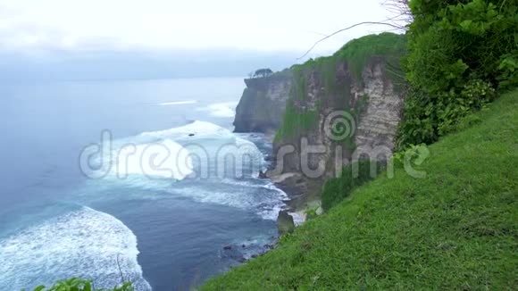 海岸线上的山崖和飞溅的海浪神奇的景观悬崖山和岩石岛蓝色海洋视频的预览图