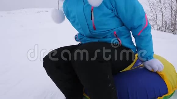 冬天女孩骑着雪碟从高山上飞过雪地快乐地笑着快乐的女人在哭泣视频的预览图