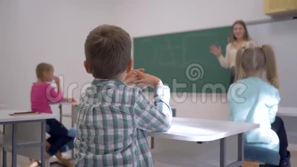 儿童教学学生上课听教育者在黑板上集中在学校的课堂上视频的预览图