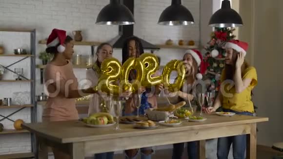 数字从箔纸2020年女孩在厨房玩在圣诞夜朋友聚会视频的预览图