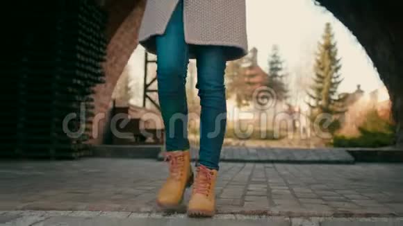 秋天或春天穿着黄色靴子的女足在城堡公园里前行视频的预览图