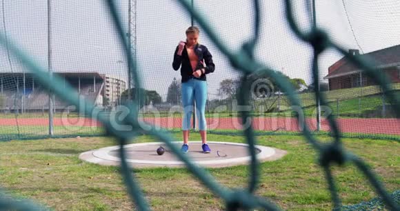 女子运动员在4k体育场地准备铅球比赛视频的预览图