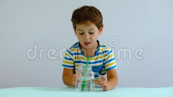 慢动作亚洲可爱的小孩在厨房里喝水开朗的男孩喜欢吹泡泡视频的预览图