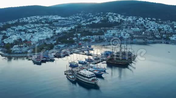有停泊船和游艇的小港口的鸟瞰图日出度假小镇博德鲁姆视频的预览图