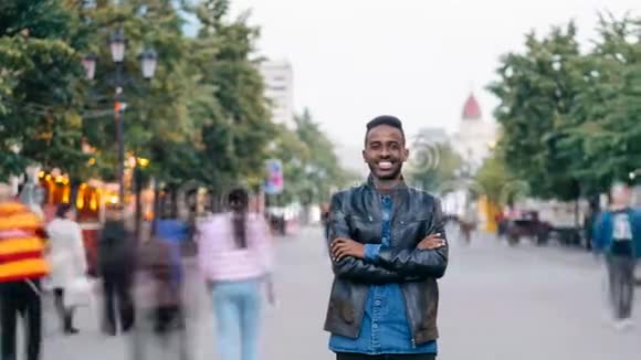 美国黑人学生看着摄像机微笑着站在街上的英俊男子的照片视频的预览图