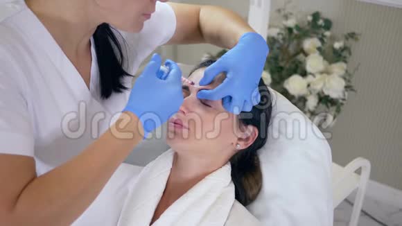 面部皮肤护理在美容院躺在沙发上接受胶原蛋白注射视频的预览图